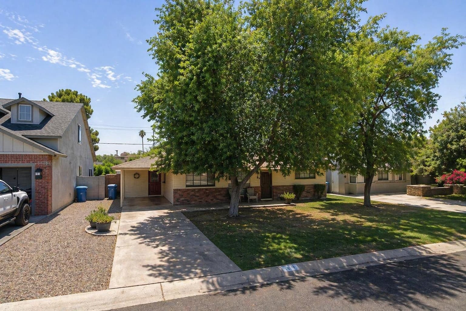 Single-story Arcadia home with mature shade trees and a brick-accented facade.